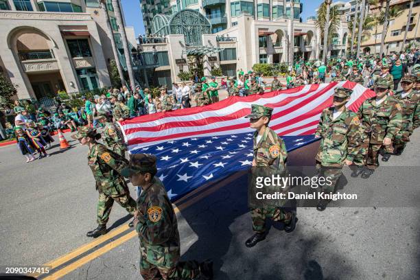 The City Heights Young Marines carry a giant American flag during the St. Patrick's Day Parade and Irish Festival at Balboa Park on March 16, 2024 in...