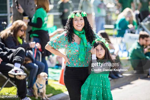 Nadiuska Clowers and Kyara Riend watch the St. Patrick's Day Parade and Irish Festival at Balboa Park on March 16, 2024 in San Diego, California.