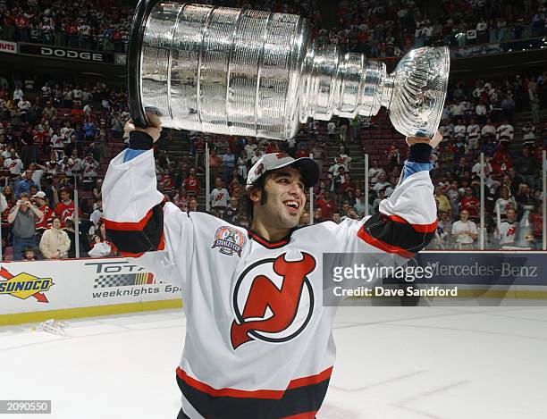 Scott Gomez of the New Jersey Devils holds up the Stanley Cup after defeating the Mighty Ducks of Anaheim in game seven of the 2003 Stanley Cup...