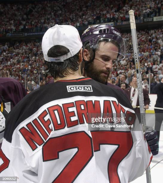 Scott Niedermayer of the New Jersey Devils and brother Rob Niedermayer of the Mighty Ducks of Anaheim hug after game seven of the 2003 Stanley Cup...