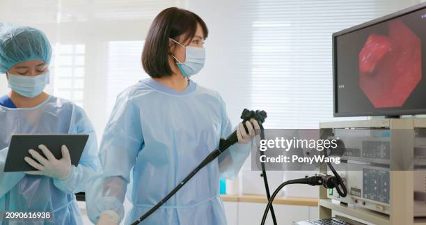 paciente de colonoscopia de médico asiático - endoscopio fotografías e imágenes de stock