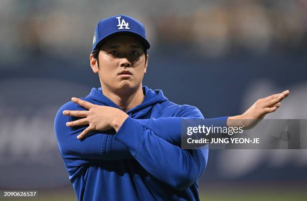 Los Angeles Dodgers' Shohei Ohtani warms up during practice at the Gocheok Sky Dome in Seoul on March 20 ahead of the 2024 MLB Seoul Series baseball...