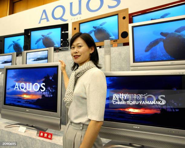 An employee of Japan's consumer electronics maker Sharp Corporation introduces its new models of liquid crystal display TV "AQUOS" series during a...