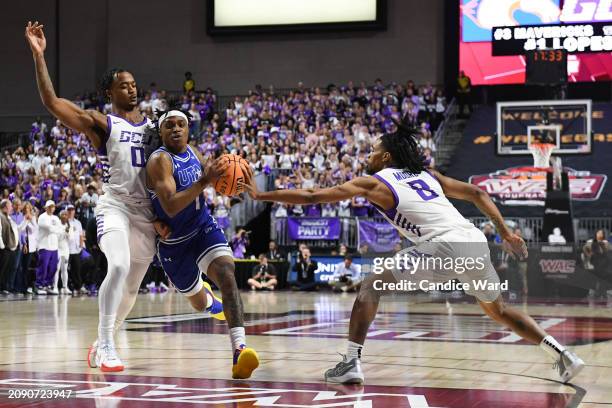 Phillip Russell of the Texas-Arlington Mavericks drives against Ray Harrison and Collin Moore of the Grand Canyon Antelopes in the first half of the...