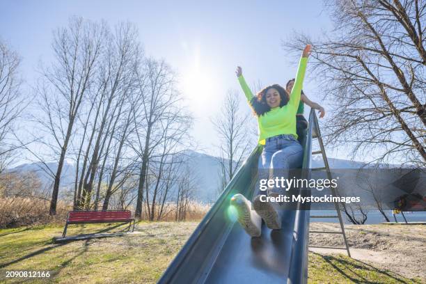 rires au bord du lac : glissades ensoleillées avec des amis - toboggan photos et images de collection