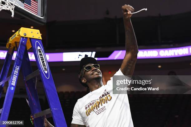 Tyon Grant-Foster of the Grand Canyon Antelopes holds up a piece of the net after defeating the Texas-Arlington Mavericks 89-74 in the championship...