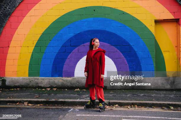 thoughtful roller skater in red by colorful mural - long coat stock pictures, royalty-free photos & images