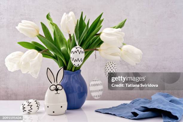 lots of white decorated easter eggs and cute easter bunny - easter tulips stock pictures, royalty-free photos & images