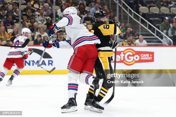 Sidney Crosby of the Pittsburgh Penguins gets caught up with Braden Schneider of the New York Rangers at PPG PAINTS Arena on March 16, 2024 in...