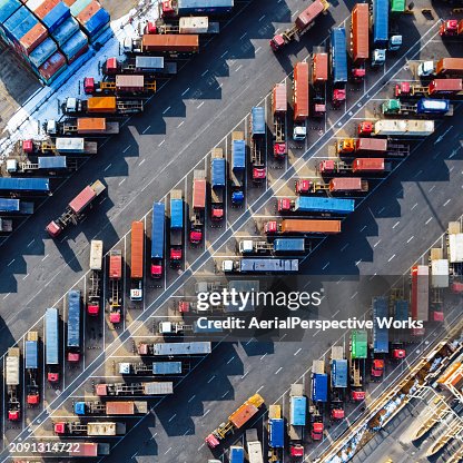 Luftaufnahme, Reihen von Lastwagen, die mit Anhängern im Hafen fahren Luftaufnahme, Reihen von Lastwagen, die mit Anhängern im Hafen fahren