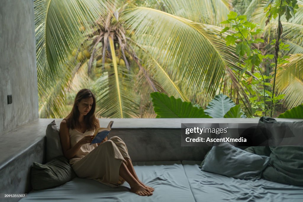 Reads Young Woman Reads Book In Open Living Room High-Res Stock Photo - Getty ...