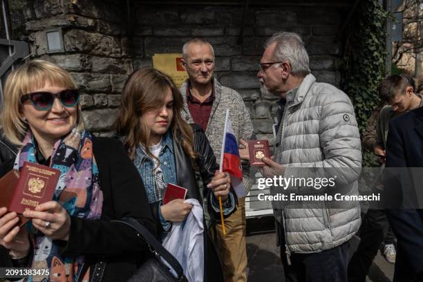 Russian citizens hold their national passport as they wait in front of the Russian consulate on March 17, 2024 in Milan, Italy. Russian citizens who...