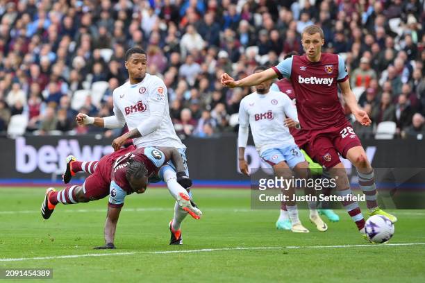 Michail Antonio of West Ham United scores his team's first goal whilst under pressure from Ezri Konsa of Aston Villa during the Premier League match...