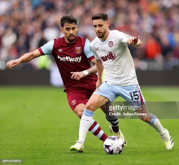 Alex Moreno of Aston Villa runs with the ball whilst under pressure from Lucas Paqueta of West Ham United during the Premier League match between...