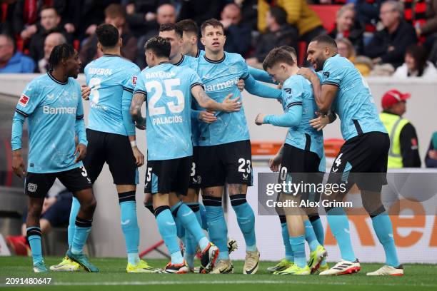 Florian Wirtz of Bayer Leverkusen celebrates scoring his team's first goal with teammates during the Bundesliga match between Sport-Club Freiburg and...