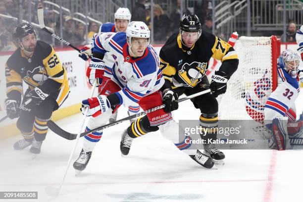 Alex Wennberg of the New York Rangers against Jeff Carter of the Pittsburgh Penguins at PPG PAINTS Arena on March 16, 2024 in Pittsburgh,...