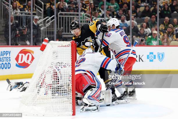 Rickard Rakell of the Pittsburgh Penguins attempts shot on goal against Jonathan Quick and Jack Roslovic of the New York Rangers at PPG PAINTS Arena...