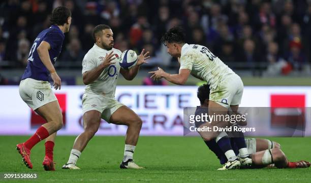Marcus Smith of England passes the ball to team mate Ollie Lawrence during the Guinness Six Nations 2024 match between France and England at Groupama...