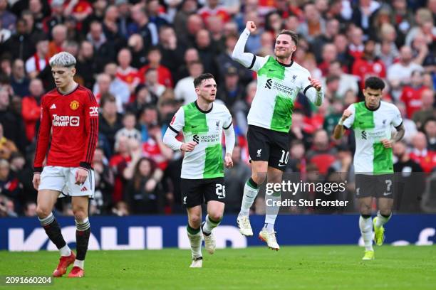 Alejandro Garnacho of Manchester United looks dejected as Alexis Mac Allister of Liverpool celebrates scoring his team's first goal with teammates...