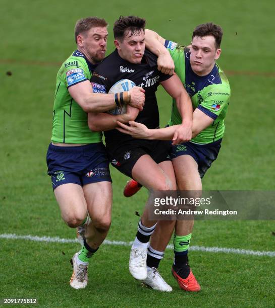 Alex Walker of London Broncos is tackled by Matt Dufty and Josh Thewlis of Warrington Wolves during the Betfred Super League match between London...