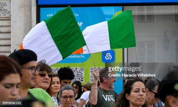 Reveler hoists two Irish flags while participating in the first Saint Patrick's Day Parade from Avenida da Liberdade to Praça do Comercio in...