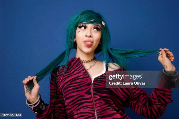 female with green hair pulling on her ponytails - eyebrow piercing stock pictures, royalty-free photos & images