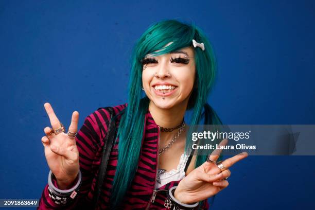 female with green hair making peace sign - eyebrow piercing stock pictures, royalty-free photos & images