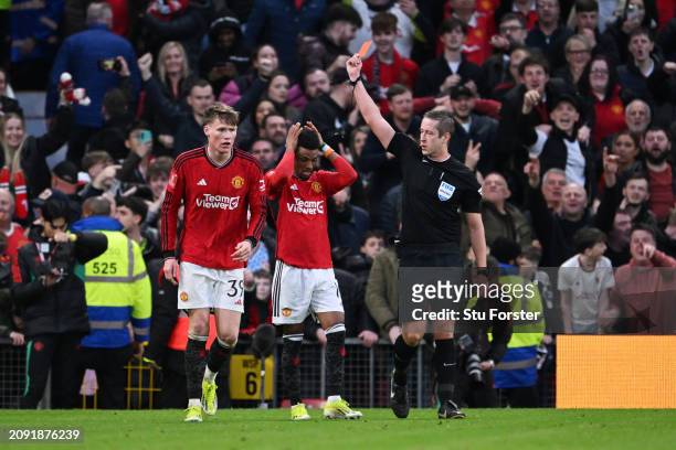 Referee John Brooks shows a red card to Amad Diallo of Manchester United, after he was shown a yellow card for removing his shirt during his...
