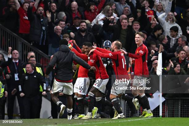 Amad Diallo of Manchester United raises his shirt to the crowd as he celebrates with teammates after scoring his team's fourth goal, which later...