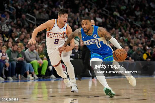 Damian Lillard of the Milwaukee Bucks dribbles the ball against Grayson Allen of the Phoenix Suns during the first half at Fiserv Forum on March 17,...
