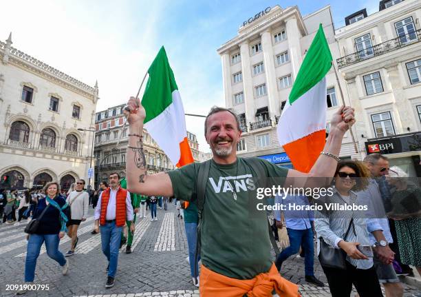 Reveler hoists two Irish flags while participating in the first Saint Patrick's Day Parade from Avenida da Liberdade to Praça do Comercio in...