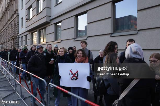 Expatriate Russian citizens, including a young group with an anti-Vladimir Putin placard, wait to vote at the Russian Embassy in Russian elections on...