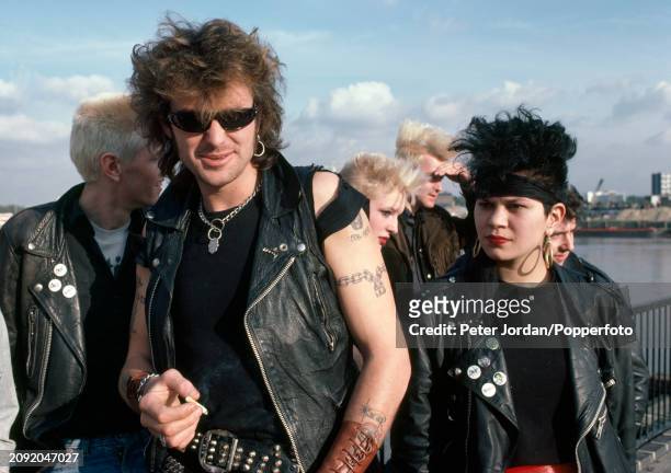 Group of Punks wearing biker jackets and studded belts beside the River Thames in London, circa 1983.