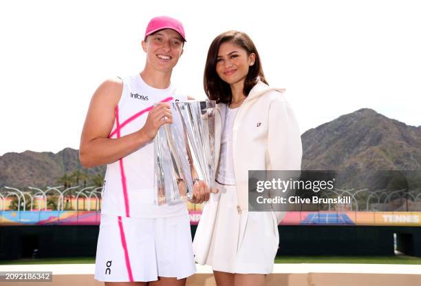 Iga Swiatek of Poland poses for a photograph with Hollywood actress Zendaya and the winners trophy after her straight sets victory against Maria...