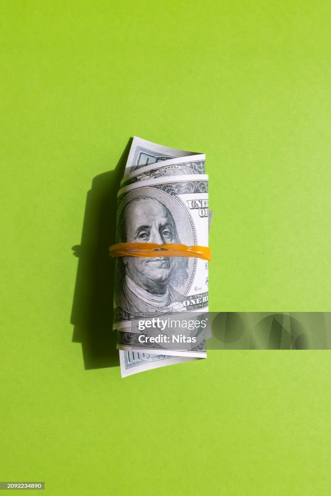 Wrapped american one hundred dollar bills on green background