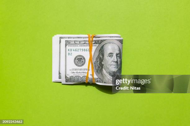 wrapped american one hundred dollar bills on green background - banconota da 1 dollaro statunitense foto e immagini stock