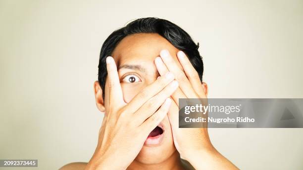close up of man see scary movie and close his face - hands covering eyes stock pictures, royalty-free photos & images