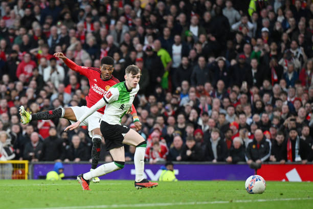 Amad Diallo of Manchester United scores his team's fourth goal whilst under pressure from Conor Bradley of Liverpool during the Emirates FA Cup...