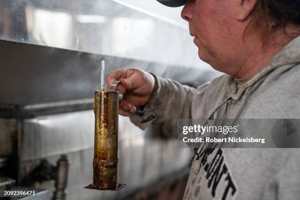 Maple syrup maker Carter Norris checks the density of maple syrup taken from an evaporator March 9, 2024 in Monkton, Vermont. Maple syrup is ready...