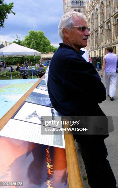 French photographer Yann Arthus-Bertrand stands next to his exhibit "Earth from the Air Seen By Blind People" which features his photos specially...
