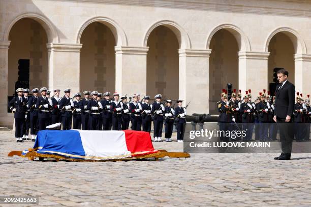 France's President Emmanuel Macron stands next to the coffin covered with a French flag during a "national tribute" ceremony to late French...