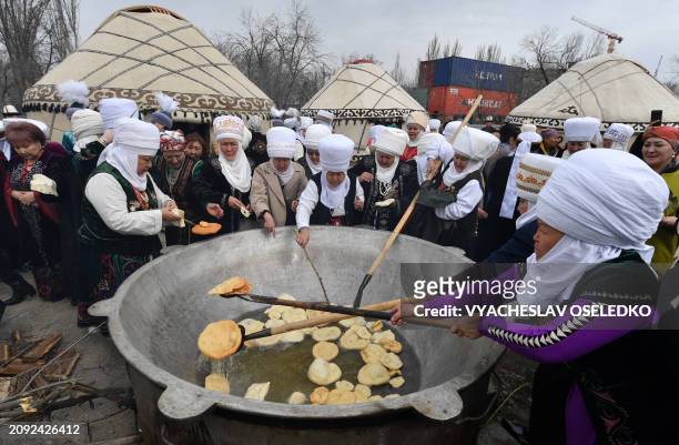 Women wearing traditional costumes cook during the celebrations of Nowruz in Bishkek on March 20, 2024. Nowruz, "The New Year" in Farsi, is an...