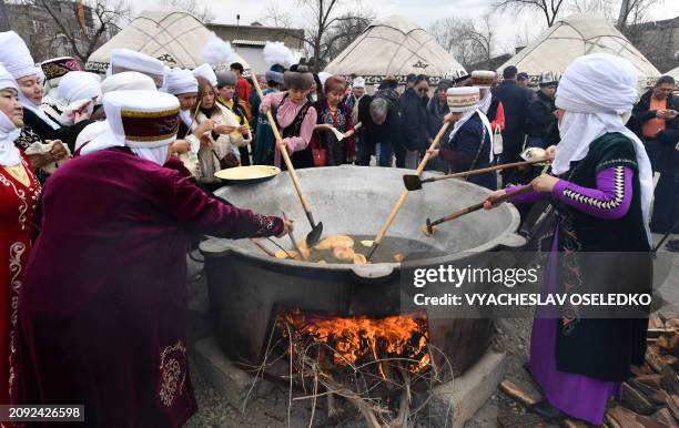 Women wearing traditional costumes cook during the celebrations of Nowruz in Bishkek on March 20, 2024. Nowruz, "The New Year" in Farsi, is an...