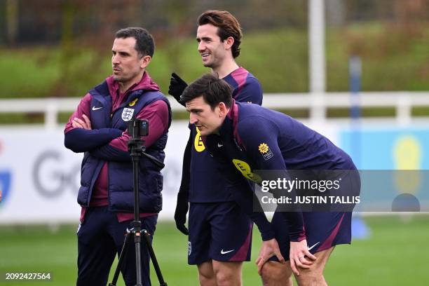 England's defender Harry Maguire watches a video on a smart phone as part of a team training session at St George's Park in Burton-on-Trent, central...