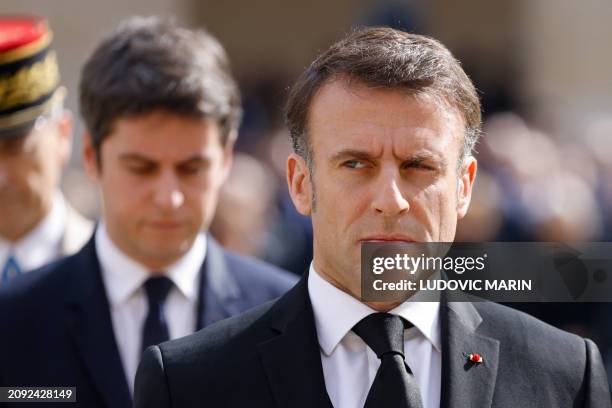 France's President Emmanuel Macron looks on, flanked by France's Prime Minister Gabriel Attal during a "national tribute" ceremony to late French...