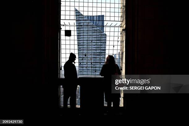 People take in the view of the Zlota 44 building, designed by Polish-American architect Daniel Libeskind, as they visit the observation deck of the...