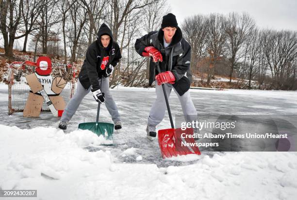 Jake Ilowiecki, left, and Dan Carley, both of Troy, shovel off a pond hockey rink on the pond at Frear Park in Troy Tuesday December 21, 2010. Both...