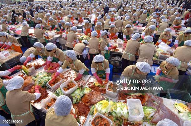 Thousands of South Korean housewives make "kimchi", the traditional pungent vegetable dish, in an event sponsored by state officials to help the...