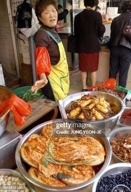 Shopkeeper offers for sale kimchi, the spicy side dish beloved by Koreans, at a market in Seoul, 03 November 2005. The Korea Food and Drug...