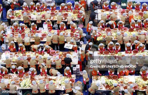 Some 2,000 South Korean housewives make 140 tons of kimchi, a traditional Korean dish of spicy fermented cabbage and radish, in a park outside the...